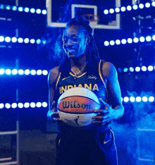 a woman in an indiana jersey holds a basketball in her hands