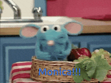 a stuffed mouse sitting in a basket with the name monica on it
