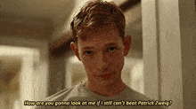 a young man is standing in a hallway and talking to another man .