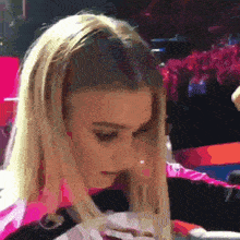 a close up of a woman 's face with a pink shirt on