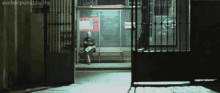 a man sits on a bench at a bus stop with the words suckerpunchlolita written above him