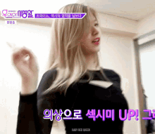 a woman with blonde hair is wearing a black shirt and a purple sticker that says baby red queen .
