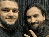 two men are posing for a picture and one of them has a piercing in his nose