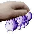 a hand is holding a pair of purple and white balls with spikes on them .