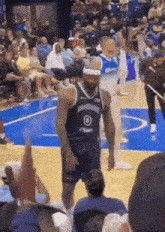 a basketball player wearing a headband with the letter o on it stands on a court