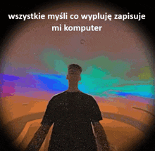 a man in a black shirt is standing in front of a colorful background with the words wszystko mysli co wypluje zapisuje mi komputer