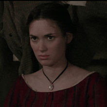 a woman wearing a necklace and a striped shirt