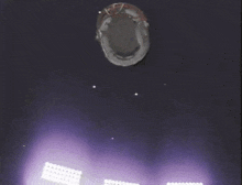 an aerial view of a stadium with purple lights behind it