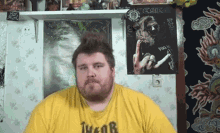 a man with a beard wearing a yellow shirt that says thor on it