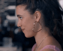 a close up of a woman wearing a pair of heart shaped earrings