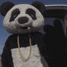 a panda bear wearing a gold chain and a cigarette in its mouth