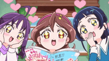 three anime girls are looking at a book that says " a " on it