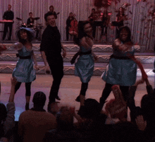 a group of people dancing on a stage with a sign that says coca cola on it