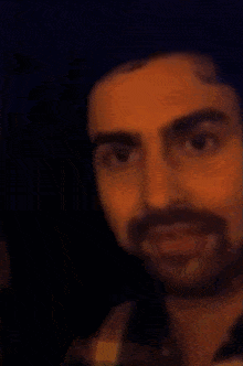 a close up of a man with a beard making a funny face