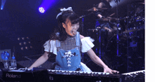 a girl is playing a keyboard that says roland on the side