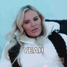 a woman in a white jacket has the word yeah written on her face
