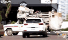 a white car is driving down a street in front of a sign that says pepe garcino