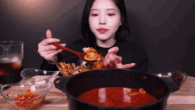 a woman is eating a bowl of food with a spoon