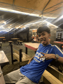 a young man wearing a blue shirt that says ccc on it