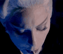 a close up of a woman 's face with a cigarette in her mouth .