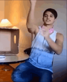 a man in a blue and white tank top is kneeling down