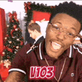 a man wearing glasses and a shirt that says v103 on it