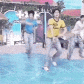 a group of men are dancing in a pool .
