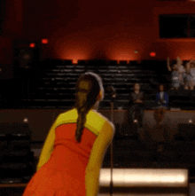 a cheerleader in a red and yellow outfit is dancing
