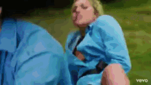 a woman in a blue shirt is sitting next to a man in a blue jacket .
