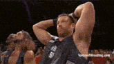 a group of wrestlers are standing in a row with their hands behind their head .