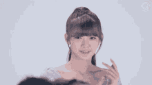 a young girl in a purple dress is smiling and pointing to her chest .
