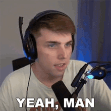 a man wearing headphones and a microphone is sitting in front of a microphone and saying yeah man .
