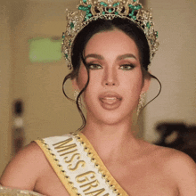 a woman wearing a miss grand sash and crown