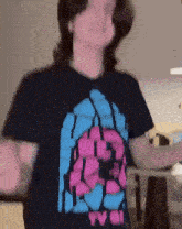 a person wearing a black shirt with a pink and blue design that says tvc