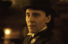 a man with his eyes closed wearing a hat and tie