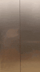 a close up of a stainless steel refrigerator door with a reflection of a person in it .