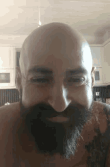 a bald man with a beard and tattoo on his arm