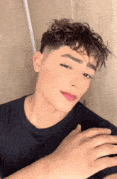 a young man with curly hair and pink lipstick looks at the camera