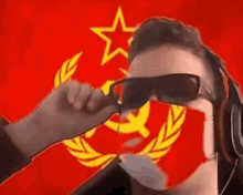 a man wearing sunglasses and a mask with a hammer and sickle on his face