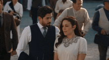 a man and a woman are walking together in a crowd