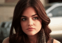 a woman with a scarf around her neck looks at the camera