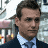 a man in a suit and tie is standing in front of a sign that says ' a ' on it