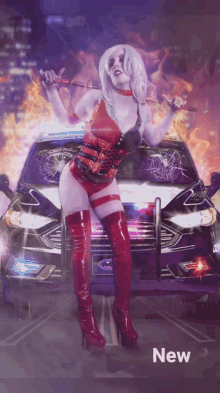 a woman in a costume stands in front of a ford car that is on fire