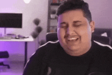 a man with a mustache is laughing with his eyes closed .