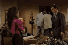 a man and a woman are standing next to each other in an office .