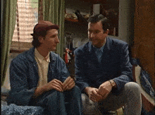 two men are kissing in a room with a picture on the wall that says " bosch "