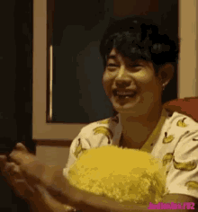 a man in a banana shirt is clapping his hands