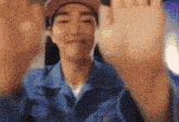 a man wearing a pink hat and a blue shirt is waving