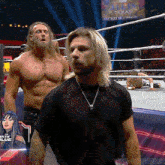 a couple of men standing in a wrestling ring with a screen behind them that says texas