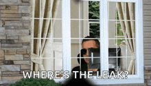 a man looking out of a window with the words where 's the leak written below him